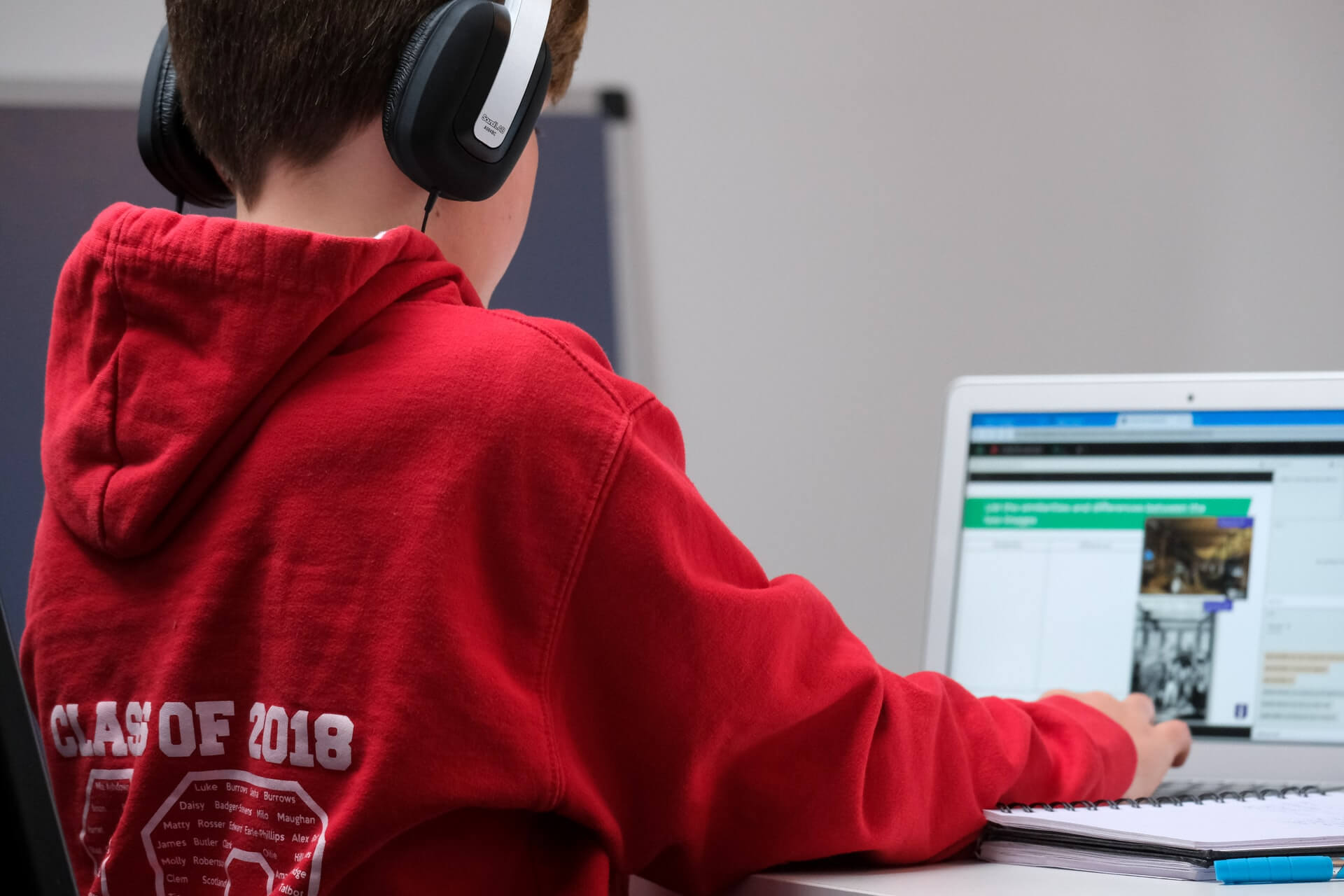student wearing headphones and using laptop