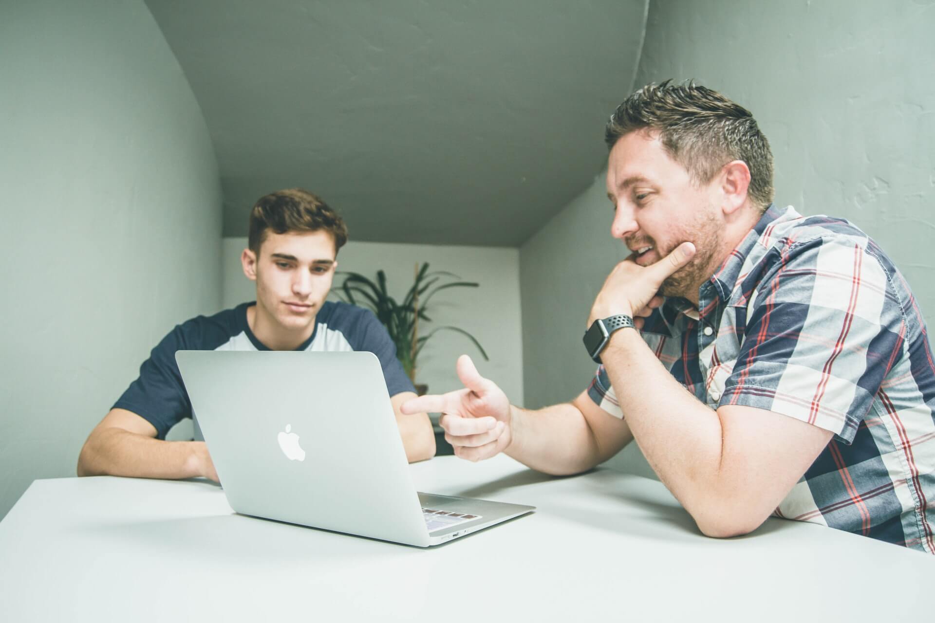 student and teacher looking at laptop