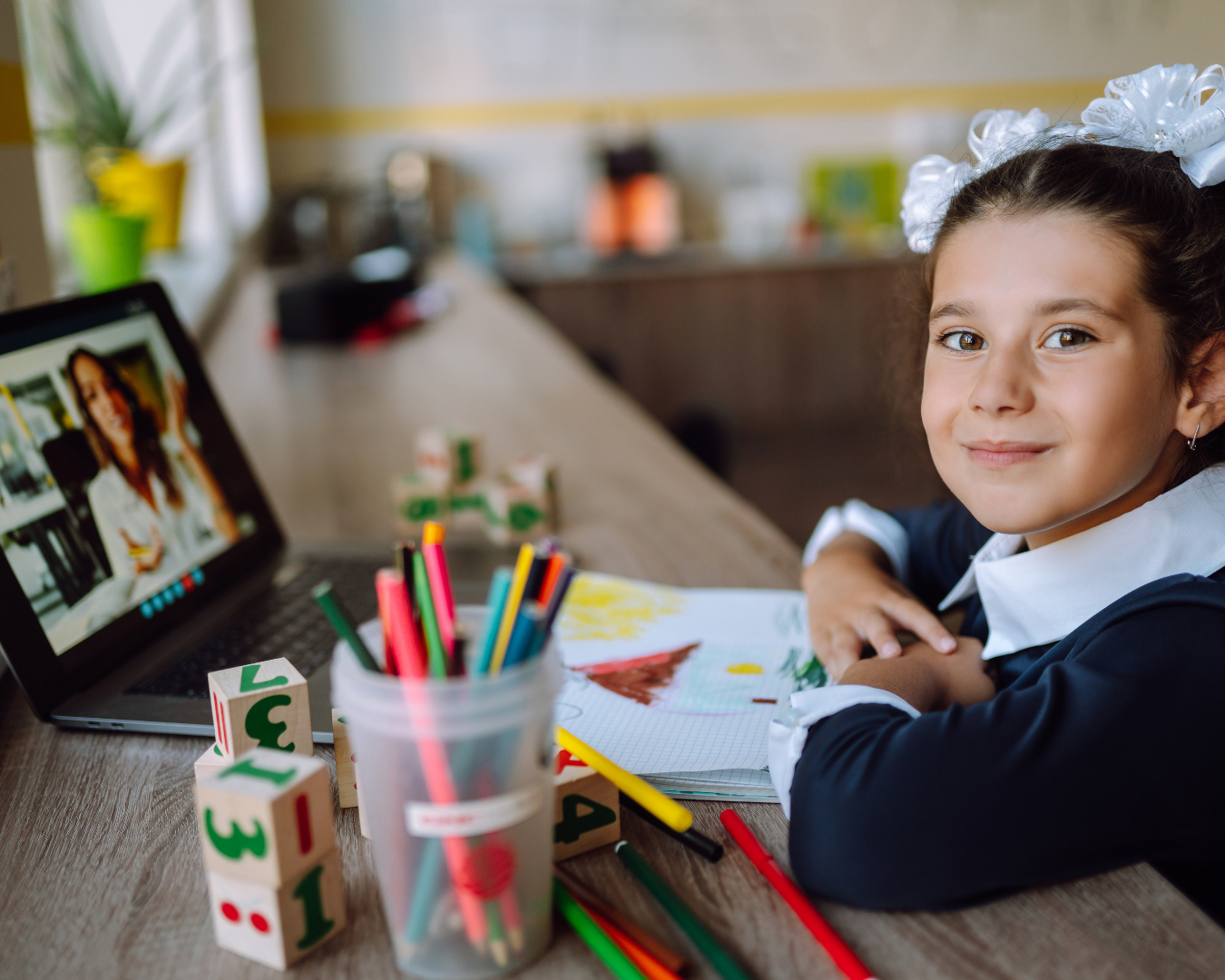 student on laptop looking at camera smiling