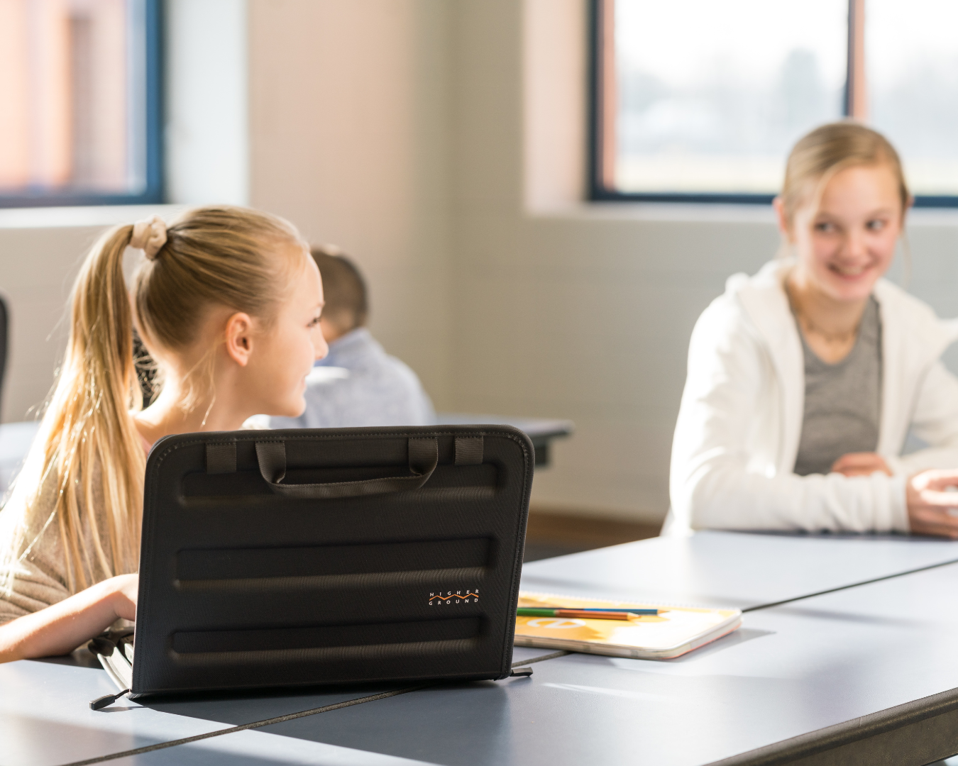 student in cafeteria using work in laptop case