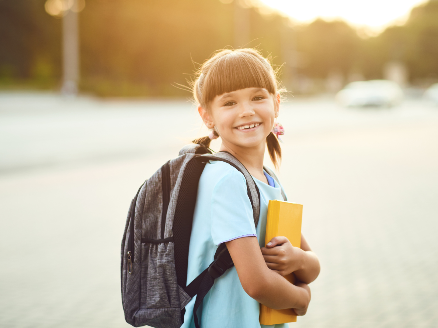 little girl with backpack on smiling at camera